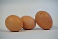 Three brown eggs on white background, one cracked Royalty Free Stock Photo