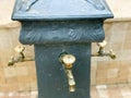 Triple gray washbasin with three carved gold taps with bronze valves for washing on the street, the beach