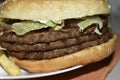 Triple meaty delicious hamburger with nice fries Royalty Free Stock Photo