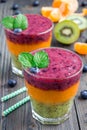 Triple smoothie in glass: kiwi-mint, mandarin-apricot and strawberry-blueberry Royalty Free Stock Photo