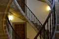 Triple spiral stone staircase perspective. Iron handrail, doors and lights. Santiago de Compostela, Spain.