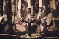 Triple vintage candlestick made of glass and black metal, two white stearin candles and one candle end. Royalty Free Stock Photo