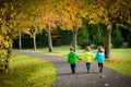 Triplet children walking on a treelined path