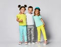 Triplets, brother and sisters. laughing and screaming loud have fun in the studio. full body shot of three children in bright clot