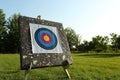 Tripod with archery target on green grass in park. Space for text