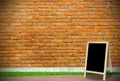 tripod blackboard in interior room with molder brick wall blackground Royalty Free Stock Photo