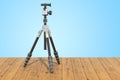 Tripod for camera or camcorder on the wooden planks, 3D rendering Royalty Free Stock Photo