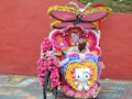 Trishaw decorated with colorful flowers waiting for customer in Malacca, Malaysia