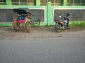 Trishaws and motorcycle resting on the street in Yogyakarta