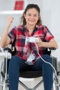 Triumphant girl in wheelchair holding computer joystick