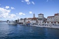 Yachts dock at the pier and tourists visit the promenade of the ancient Venetian city near the Adriatic Sea, Trogir, Croatia Royalty Free Stock Photo