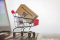 Trolley with Carton on computer keyboard. Online shopping, e-commerce and worldwide shipping concept