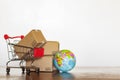 Trolley with carton and earth globe. Worldwide shopping and delivery business concept Royalty Free Stock Photo