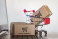 Trolley with cartons on computer. Online shopping, e-commerce and worldwide shipping concept Royalty Free Stock Photo