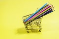 Trolley with colored pencils on a yellow background Royalty Free Stock Photo