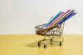 Trolley with colored pencils on a yellow and white background Royalty Free Stock Photo