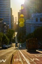 Trolley driving towards Oakland Bay Bridge between skyscrapers in morning light