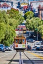 Trolley driving up hill with streetcar on bottom of hill and Clean Air Vehicle crossing road