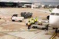 Trolley full of bags, suitcases and other luggage being loaded by ground crew