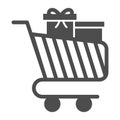 Trolley for goods with gifts solid icon, Black Friday concept, shopping cart sign on white background, Supermarket Royalty Free Stock Photo