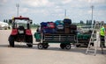 Trolley with luggage at the airport on the platform near the plane. Travelers` suitcases. Passenger suitcase. Mini tractor specia