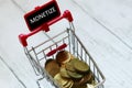 Trolley or shopping cart and gold coins with blackboard written with word monetize.Business and finance concept.