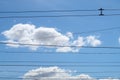 Trolleybus wires against the background of white clouds and blue sky, urban public transport. Royalty Free Stock Photo