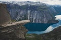 Trolltunga - famous rock formation and tourist famous hike, beautiful norwegian summer landscape with fjord, mountain and lake Royalty Free Stock Photo