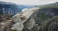 Trolltunga - famous rock formation and tourist famous hike, beautiful norwegian summer landscape with fjord, mountain and lake Royalty Free Stock Photo