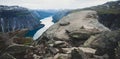 Trolltunga - famous rock formation and tourist famous hike, beautiful norwegian summer landscape with fjord, mountain and lake