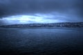 Tromsoe city island during heavy weather fog and mist over houses and blue fjord landscape