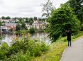 Trondheim/Norway - July, 6 2019: Uncertain young man with a beard in a black cloak takes a beautiful view of the city and the Royalty Free Stock Photo