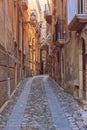 Stone buildings walls of narrow street lane in old Tropea town, Italy