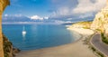 Tropea town and beach, yacht boat in Tyrrhenian Sea, colorful buildings on top of high big rocks Royalty Free Stock Photo