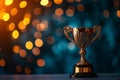 Trophy with two handles, reflective gold finish, set against a soft-focus background with light speckles Royalty Free Stock Photo