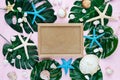 Tropic flat lay with empty wooden frame starfish, shells, tropic leaves on pink background. Summer fashion flat lay, vacation Royalty Free Stock Photo