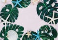 Tropic monstera leaves, starfish, shells on pink background. Summer fashion flat lay, vacation, travel concept. Top view