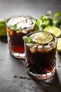 Tropical alcoholic cocktail Cuba Libre composed of white rum, cola, ice cubes, lime and mint Royalty Free Stock Photo