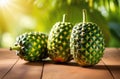 guanabana on a wooden table, green plants on a background, exotic garden, sweetsop or custard apple, sunny