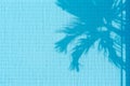 Tropical background of palm tree leaf reflection in the blue water surface of swimming pool. Abstract background with openwork Royalty Free Stock Photo