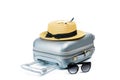 Tropical background. Suitcase, sunglasses with toy plane and straw hat in travel composition isolated on white Royalty Free Stock Photo