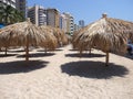 Tropical bamboo umbrellas on sandy beach at bay of ACAPULCO city in Mexico with hotel buildings Royalty Free Stock Photo