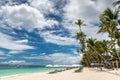 Tropical beach background from Alona Beach at Panglao Bohol island with Beach chairs on the white sand beach with cloudy blue sky Royalty Free Stock Photo