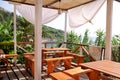 Tropical beach cafe bar at coastline by sea with outdoor view. Terrace balcony, relax place for eating and drinks of seaside. Royalty Free Stock Photo