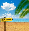 Tropical beach and direction board saying NEW HOME