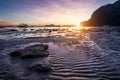Tropical beach in ebb time low tide on sunset. Mudflats and sun reflections at the golden hour. mountain chain isles at Royalty Free Stock Photo