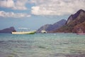 Tropical beach with isles and white boat foreground. Seascape with yacht and boats on island background.