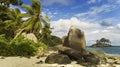 Tropical beach with palm trees, rocks, white sand and blue sky on Mahe island, Seychelles Royalty Free Stock Photo