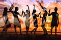 tropical beach party, group of young people dancing, friends drinking beer and cocktails, silhouettes Royalty Free Stock Photo