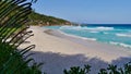 Tropical beach Petite Anse with turquoise colored water, granite rock formations and strong waves.